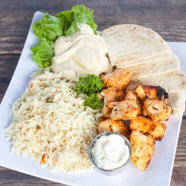 LE Chef Mediterranean chicken shish tawook with rice, hummus, pita bread, and lettuce.