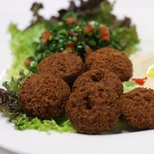 Crispy falafel balls on a bed of fresh lettuce with tabbouleh and hummus.