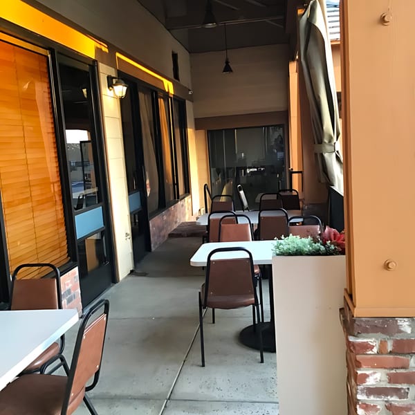 Outdoor patio dining area at LE Chef Mediterranean with tables, chairs, and warm lighting.